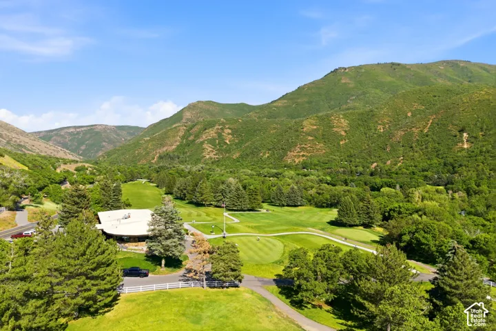 Expansive green space featuring a golf course, mature trees, and a mountain backdrop