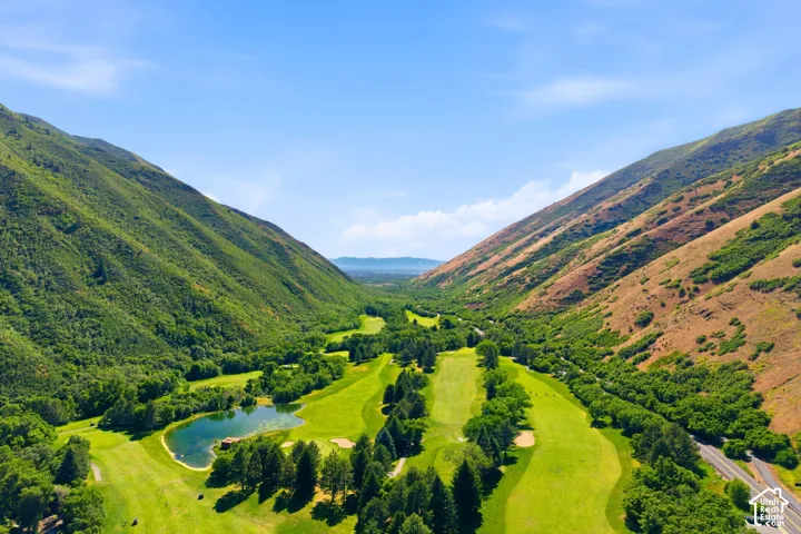 Expansive golf course surrounded by lush green and arid mountains