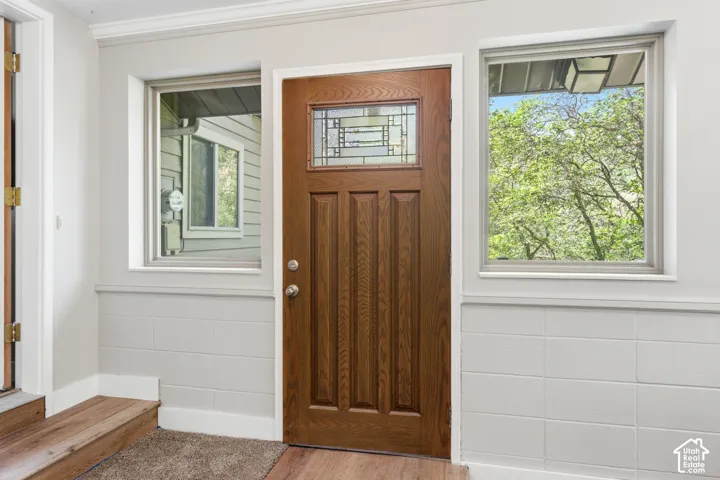 Solid wood entry door with decorative stained glass, flanked by two sidelight windows