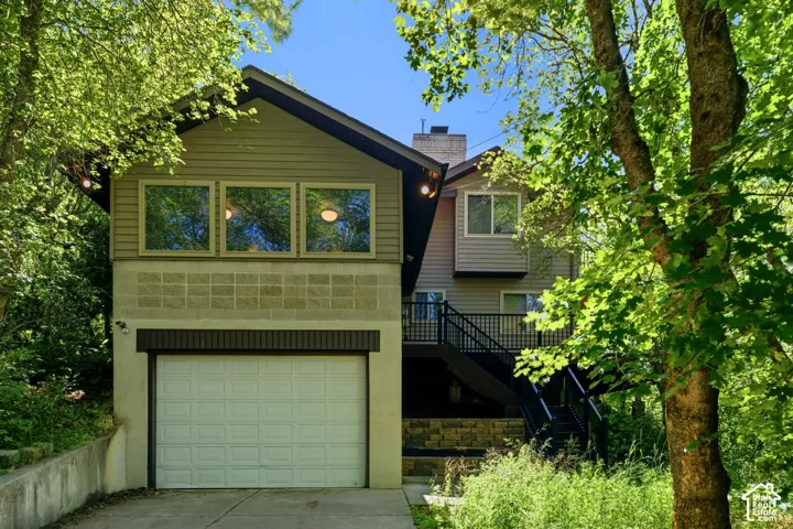 Multi-level exterior with horizontal siding and a prominent two-car garage