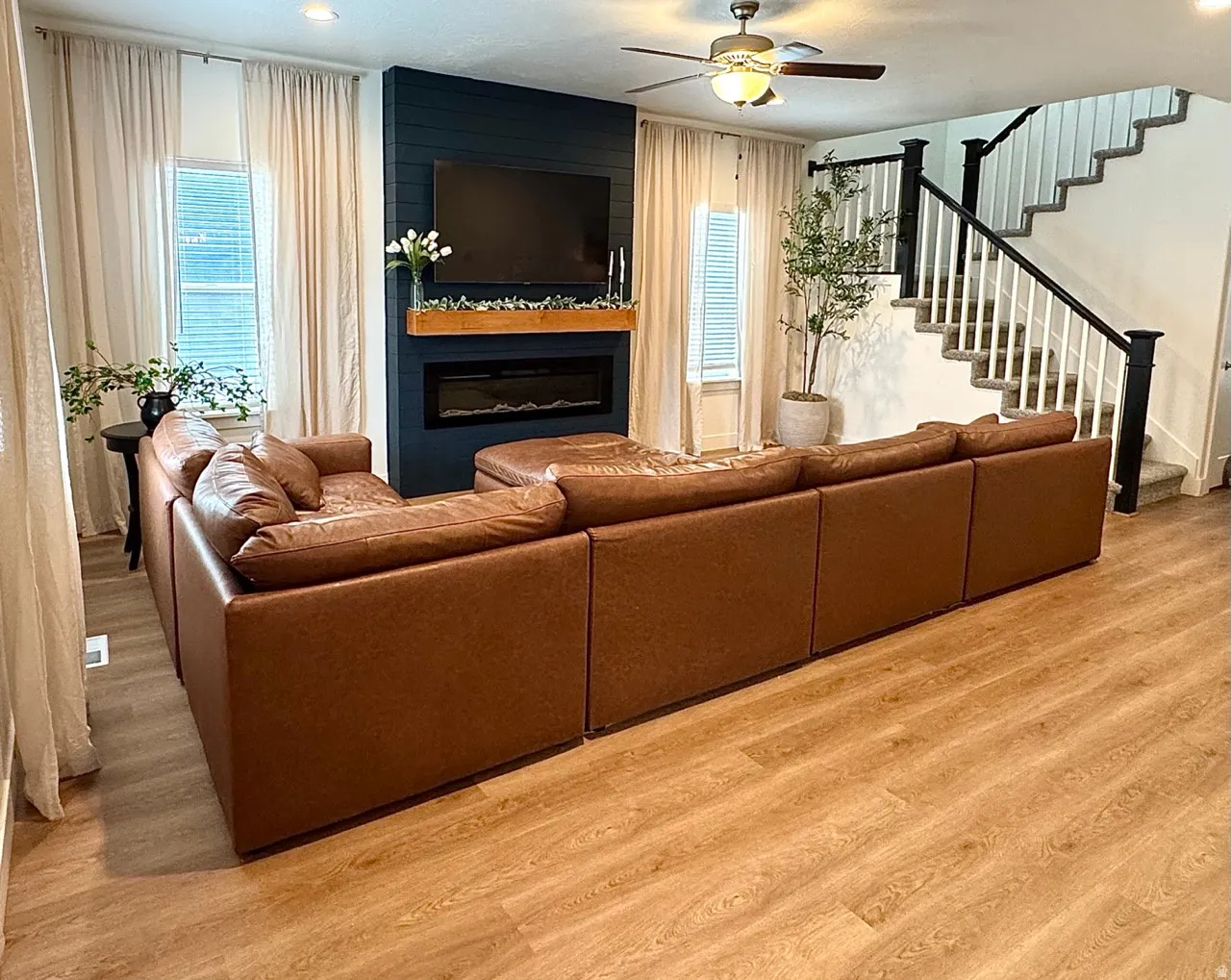 Living area with wood-finish flooring and a central fireplace feature wall