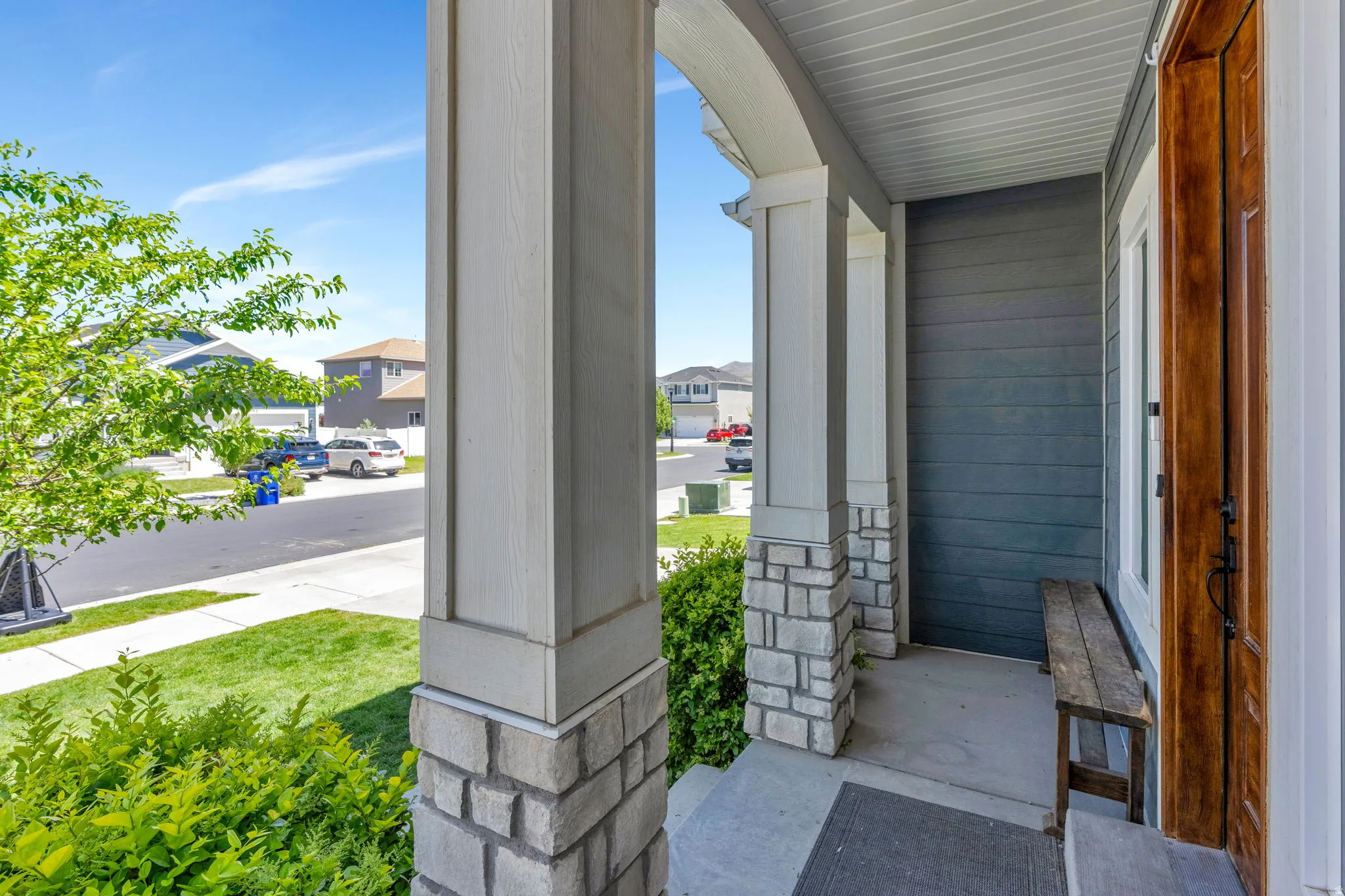 Covered front porch featuring robust columns with stone bases