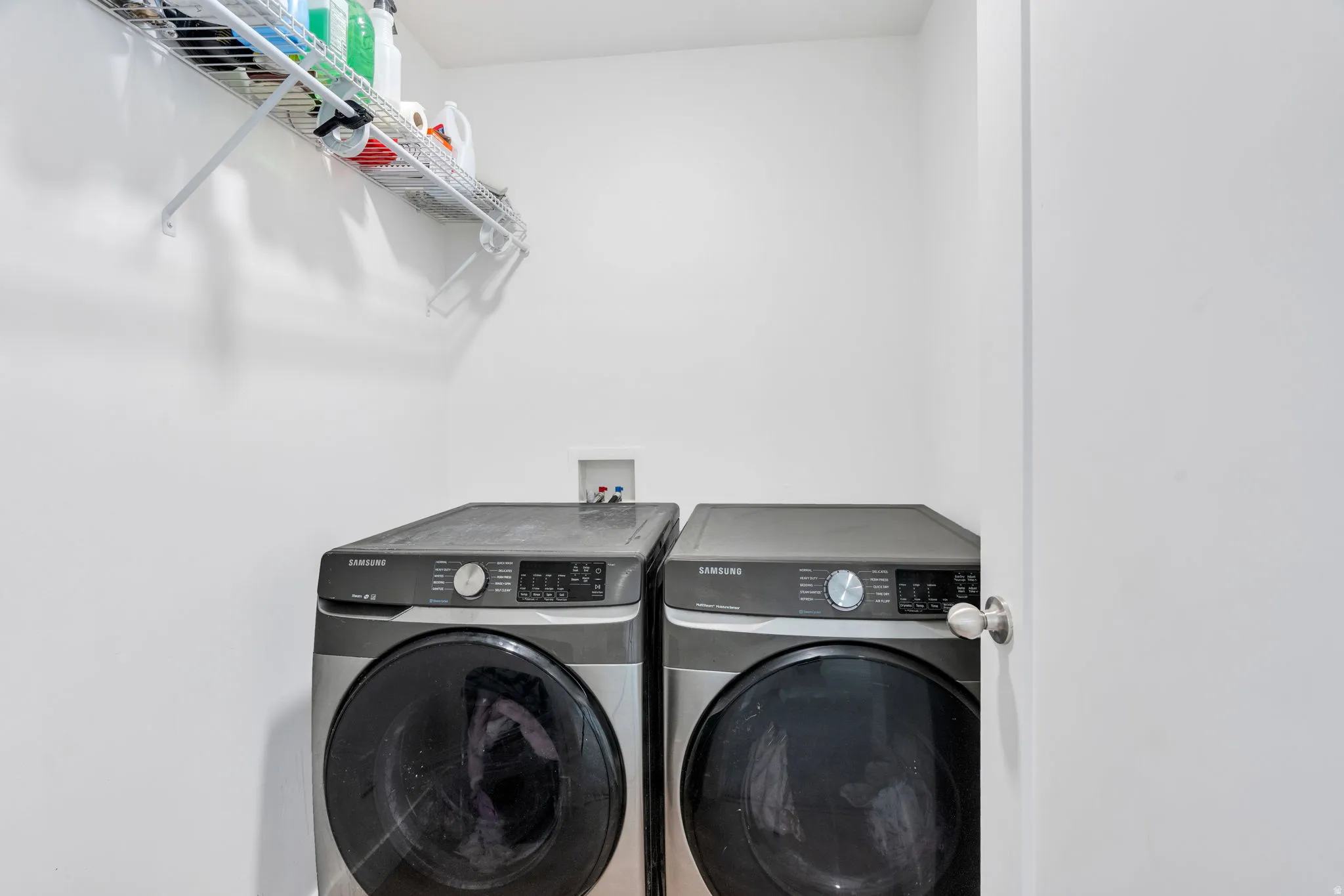 Dedicated laundry space featuring a wire shelf for storage