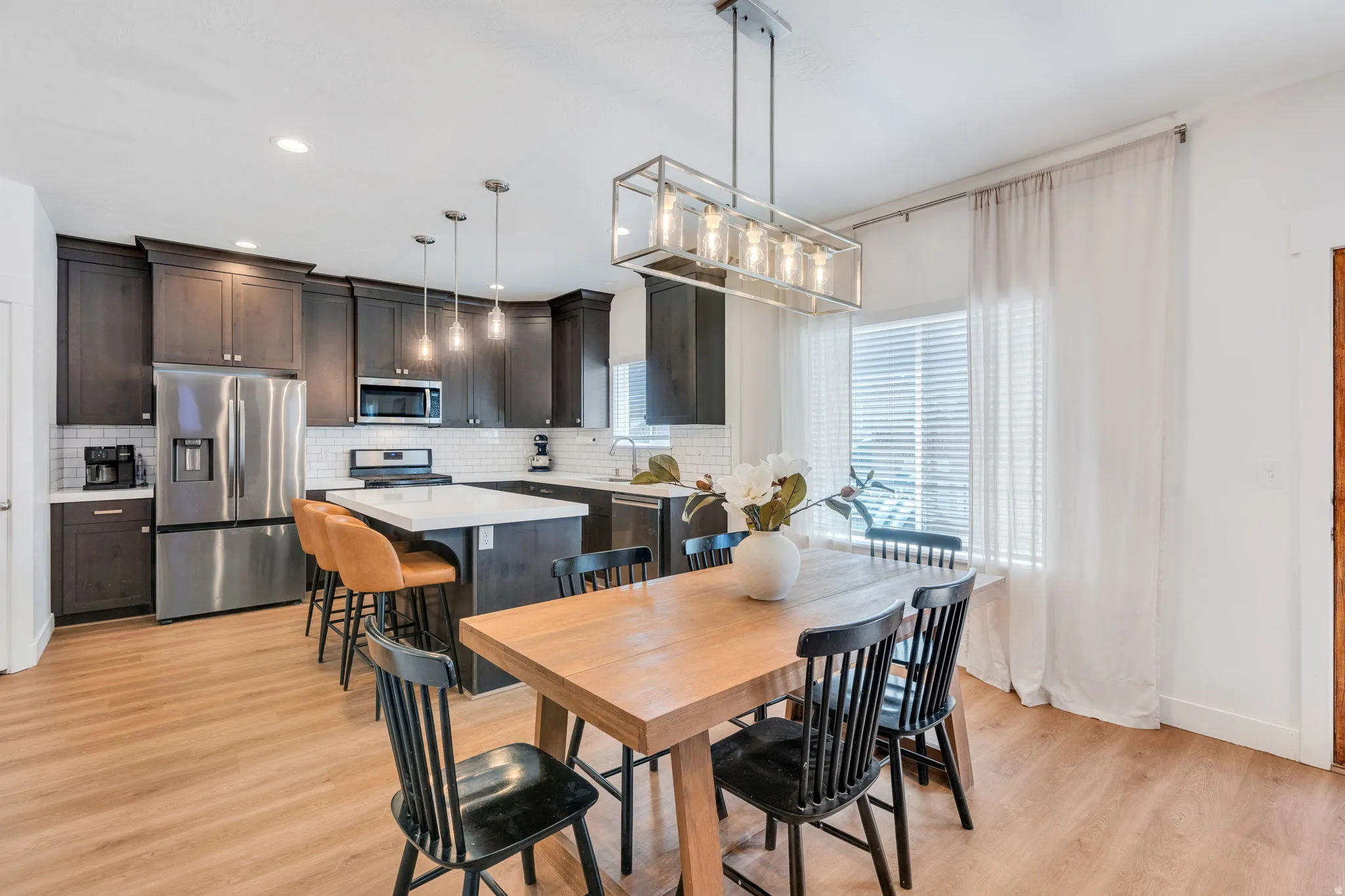 Open-concept kitchen and dining area featuring wood-finish flooring