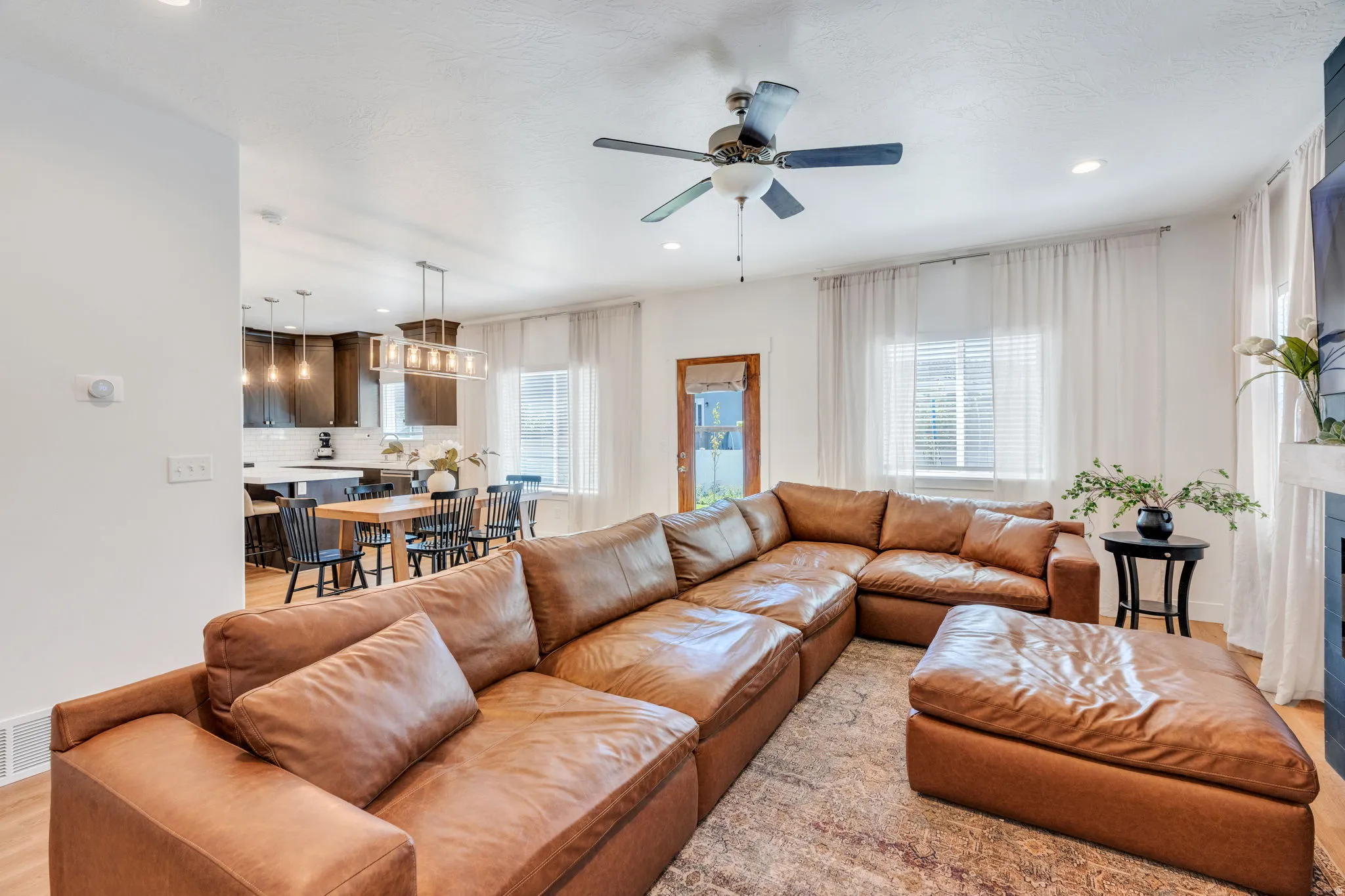 Open-concept living space featuring wood-finish flooring, recessed lighting, and a ceiling fan
