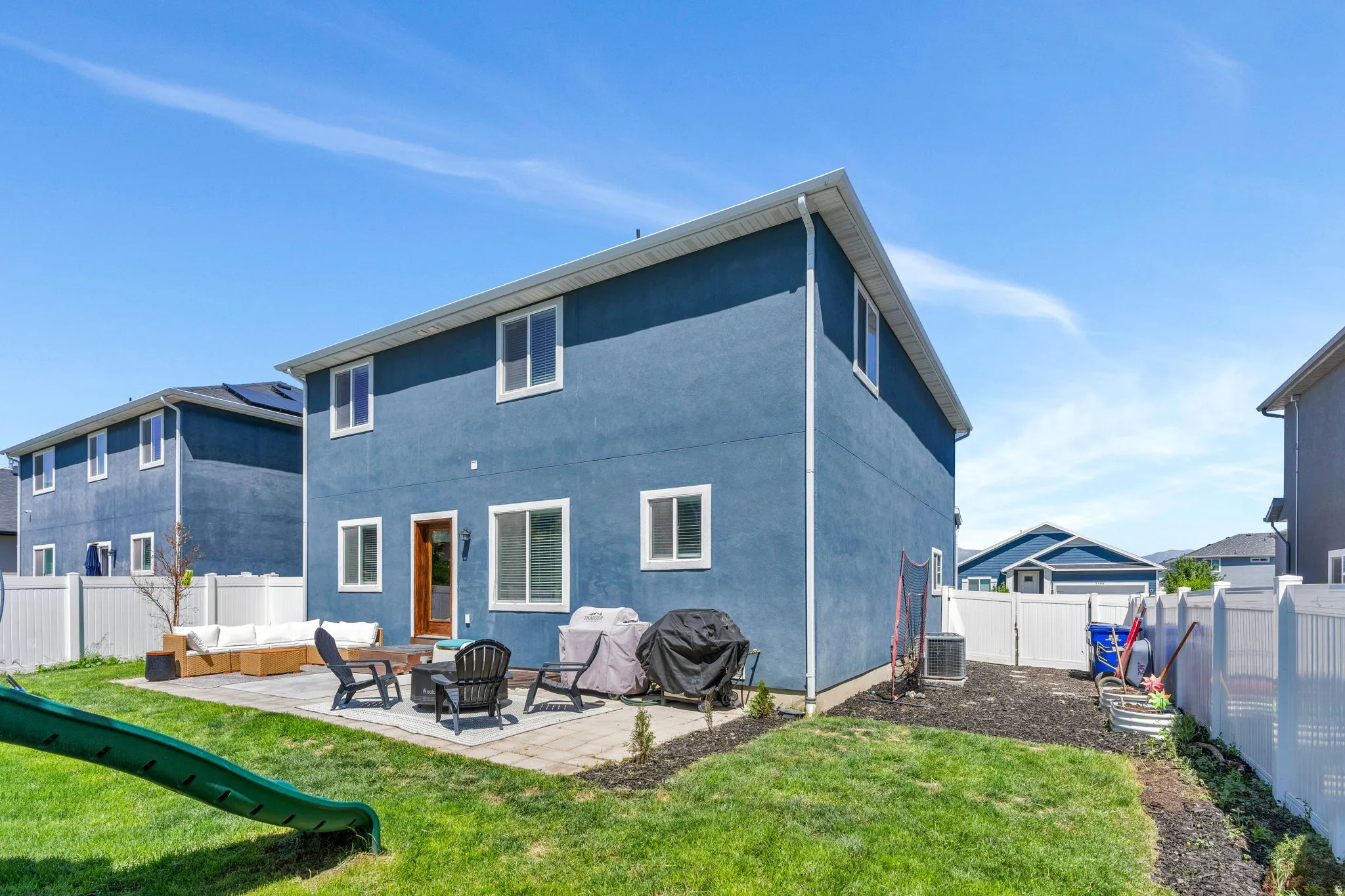 Rear exterior featuring a ground-level patio, a fenced yard, and an exterior door with frosted glass detailing