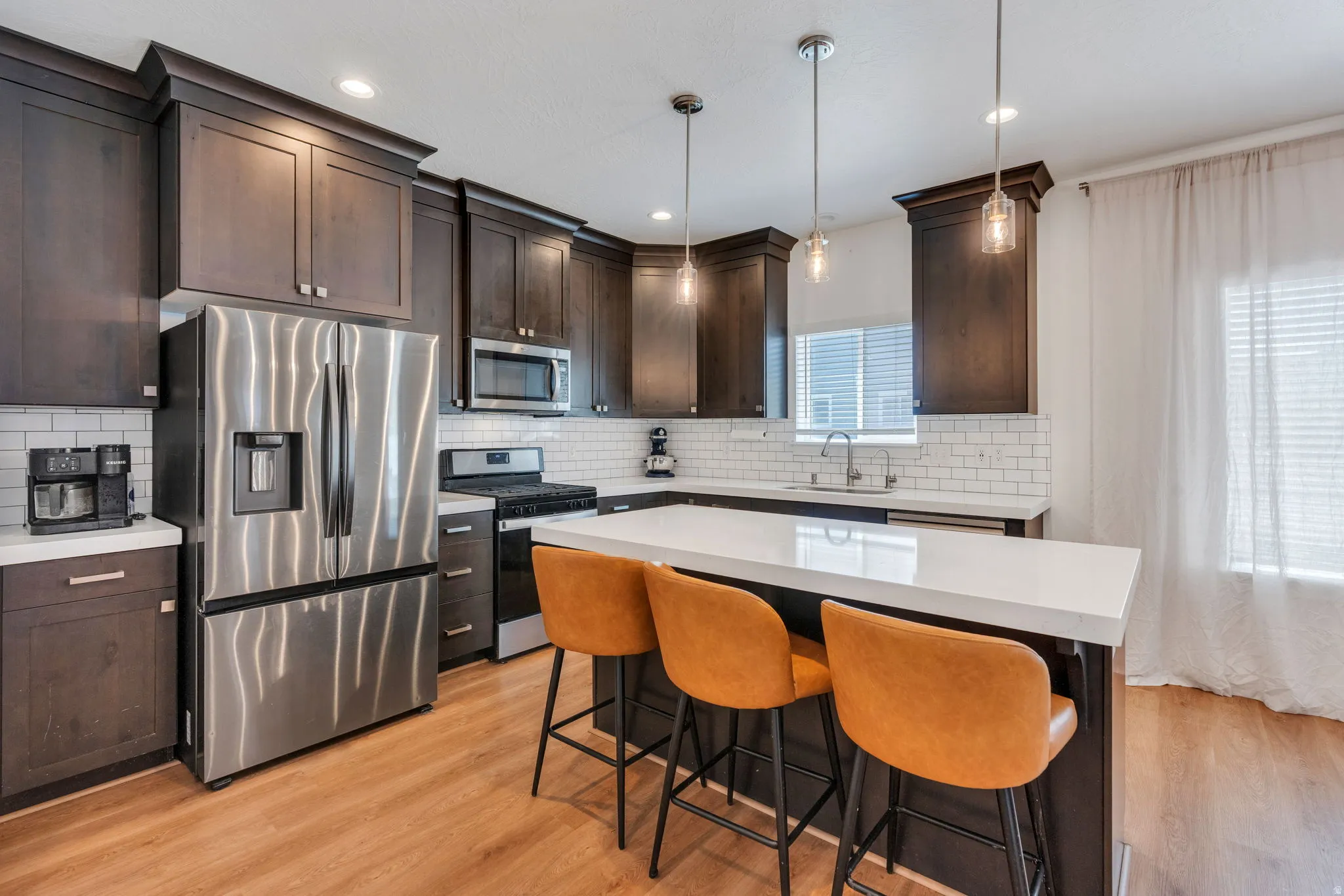 Modern kitchen featuring dark wood-finish cabinetry and a white subway tile backsplash