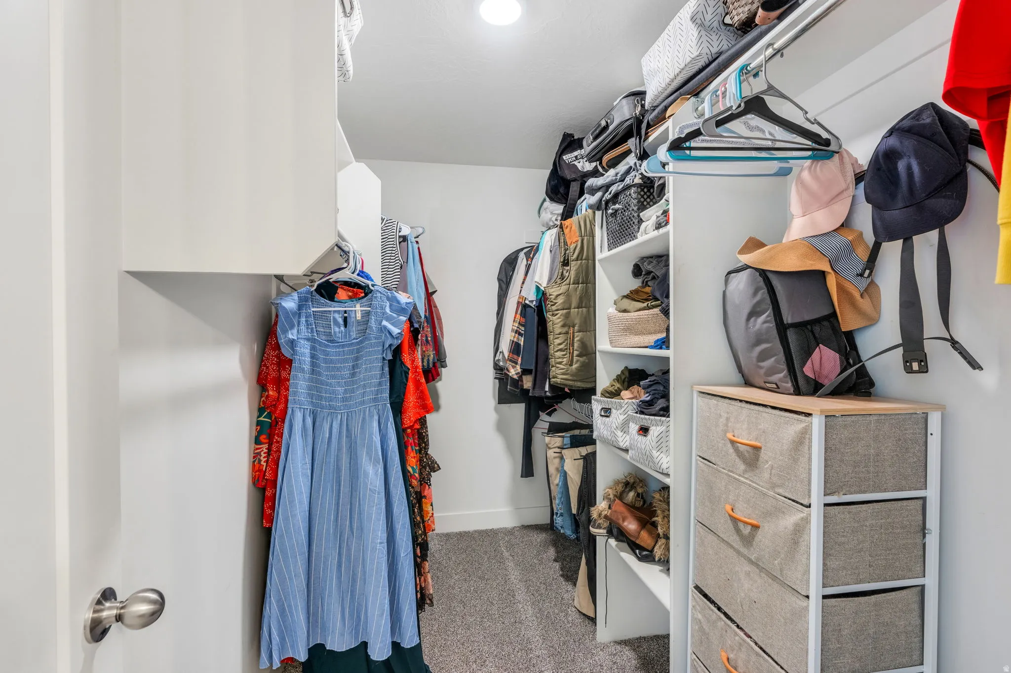 Walk-in closet featuring built-in shelving, hanging rods, and recessed lighting
