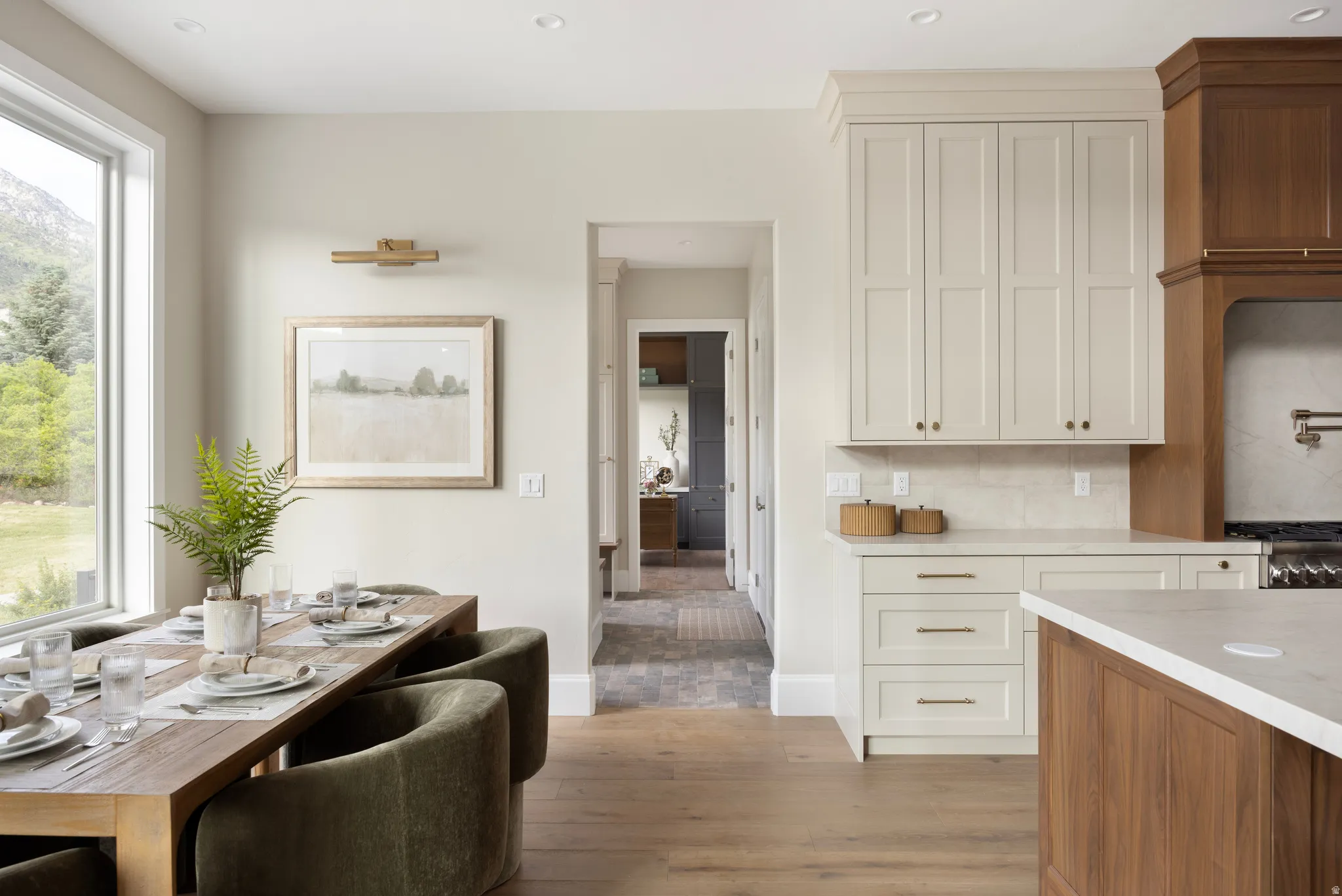 Open-concept dining and kitchen space featuring light wood-finish flooring