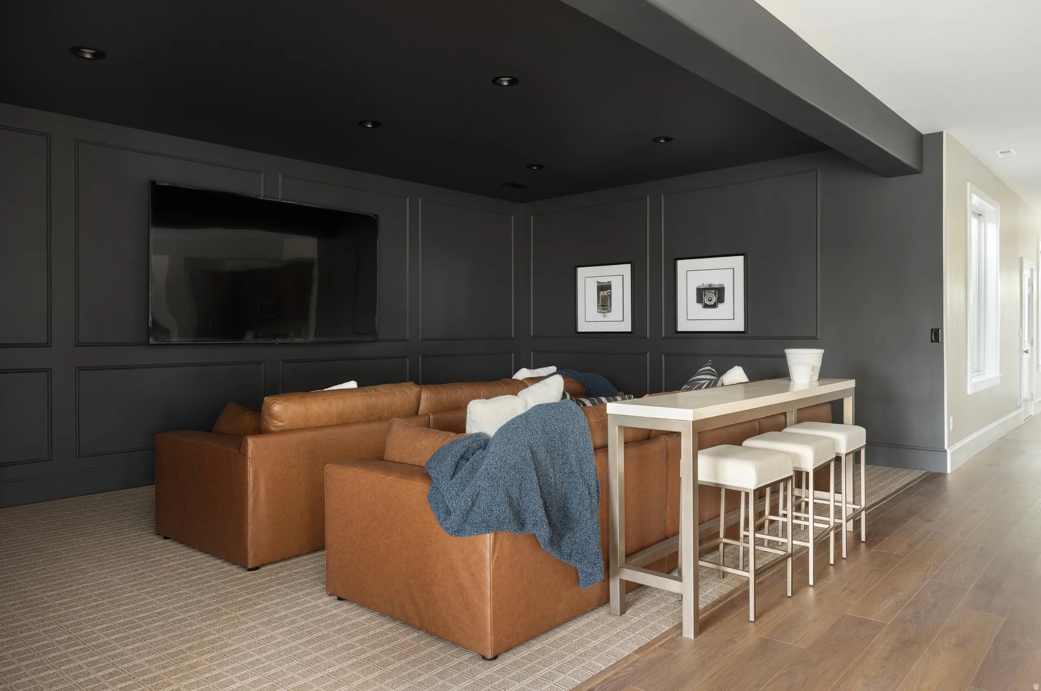 Media room featuring wainscoting paneling, recessed lighting, and a dark ceiling