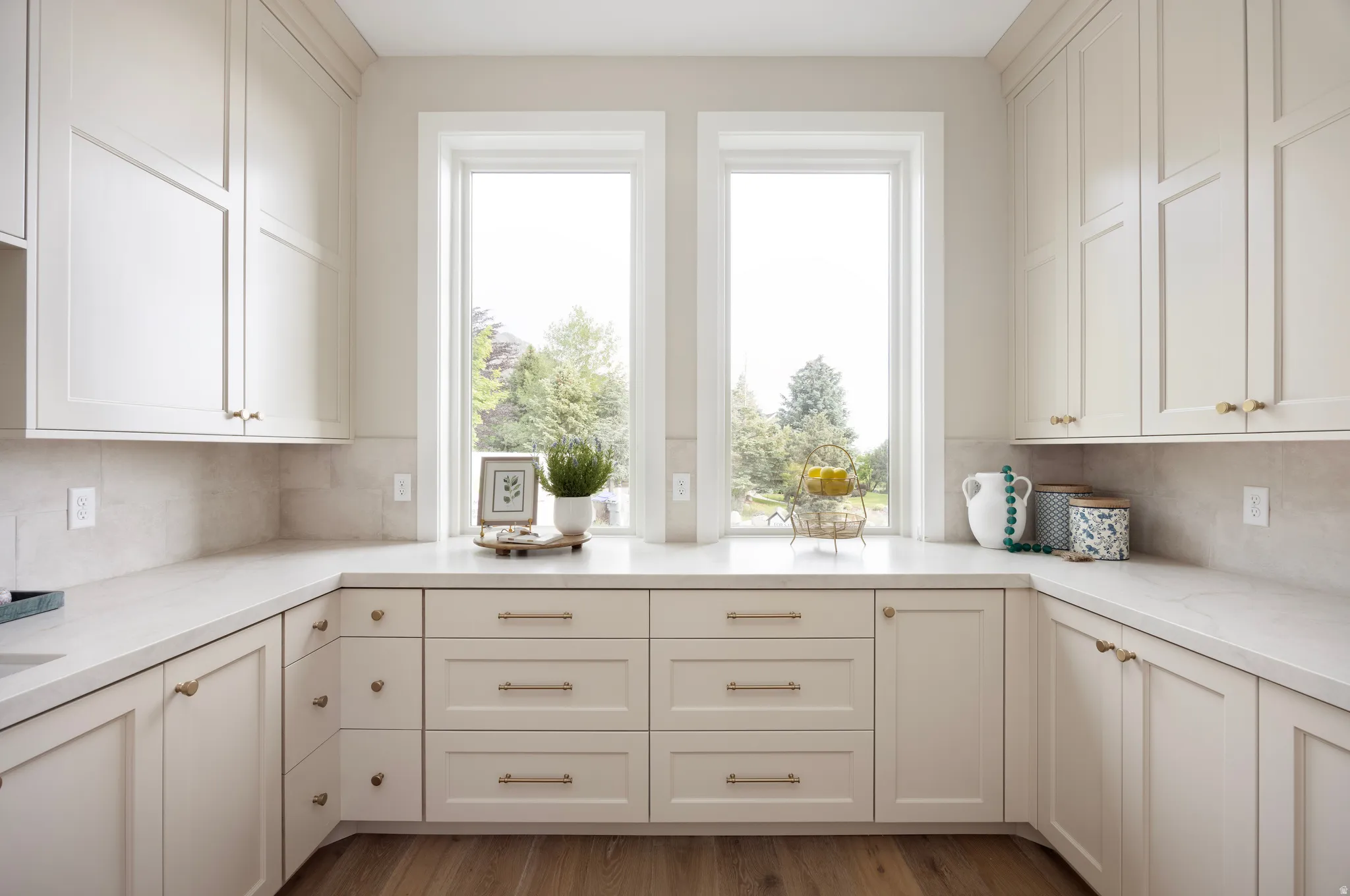 Kitchen featuring white shaker-style cabinetry, light-toned countertops, and a subway tile backsplash