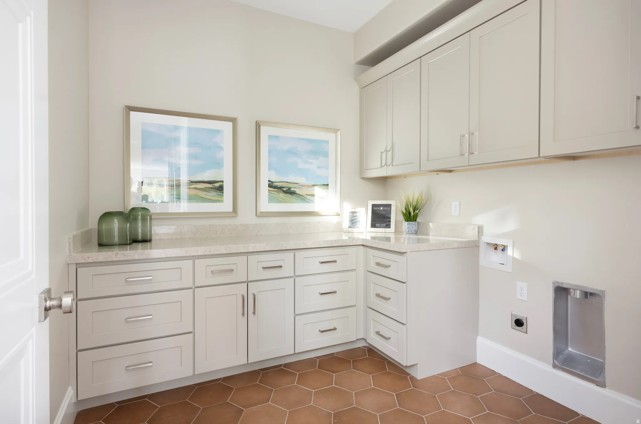 Laundry room featuring hexagon tile flooring, light-toned cabinetry with brushed nickel hardware, and light-toned countertops