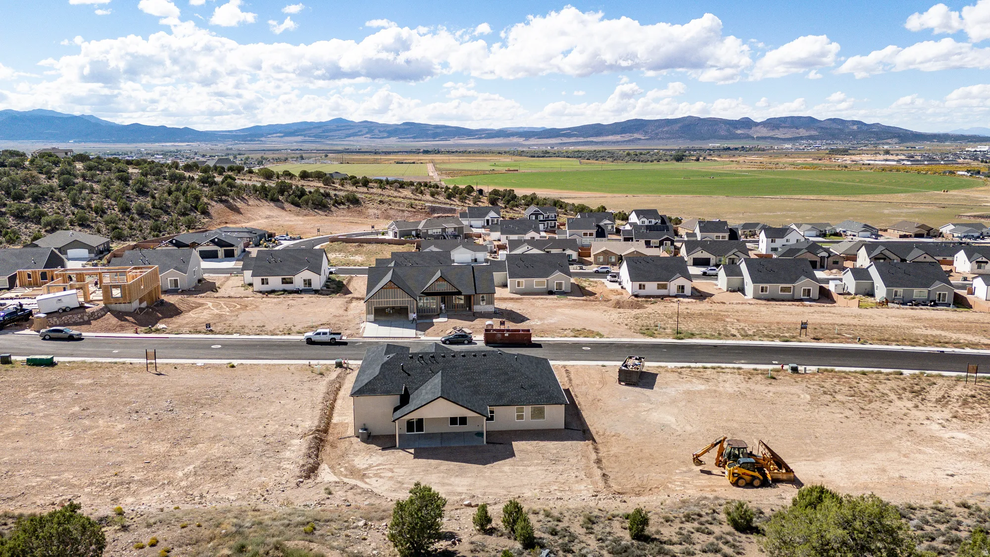 New construction residential development featuring a paved street and surrounding mountain ranges