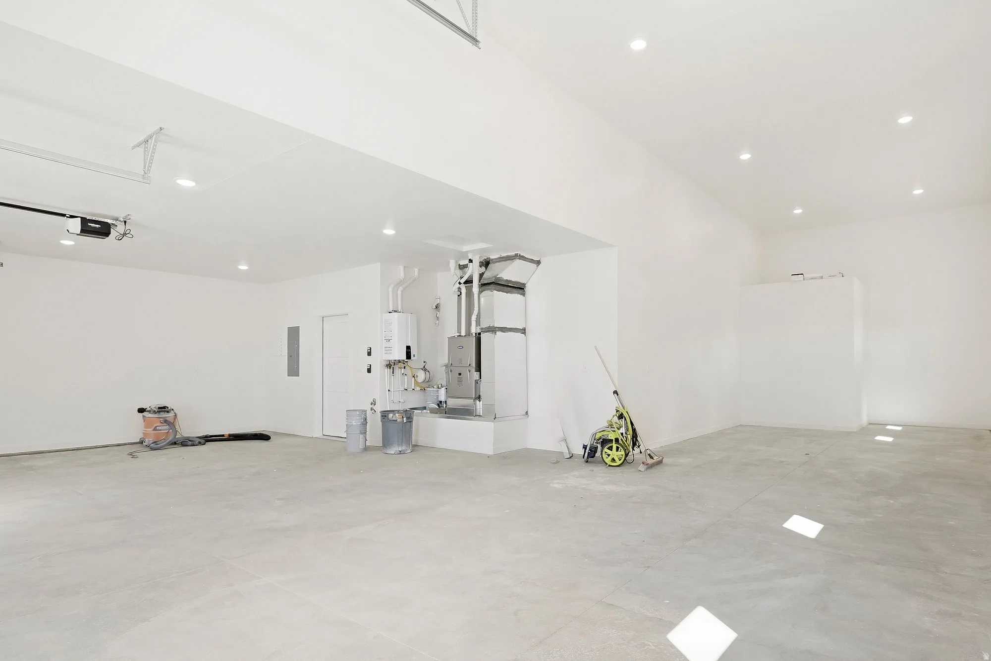 Spacious garage with concrete flooring, recessed lighting, and a white overhead garage door opener
