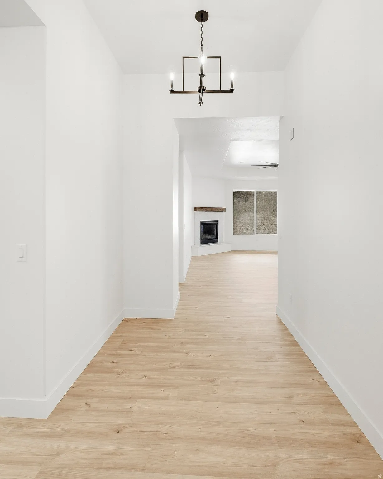 Wood-finish flooring throughout, complemented by a contemporary chandelier