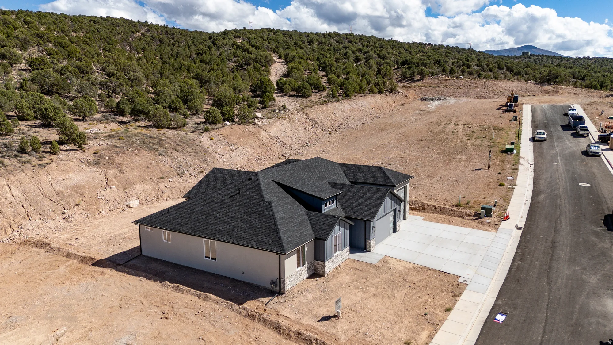 Contemporary single-story home featuring a dark shingle roof, light-colored siding, and stone accents