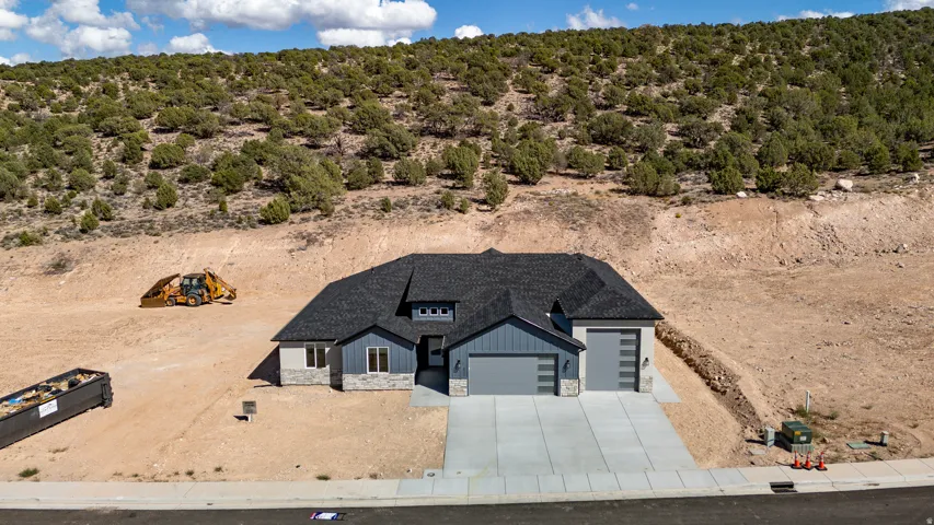 Contemporary home with a dark shingle roof, light grey siding, stone accents, and a two-car garage