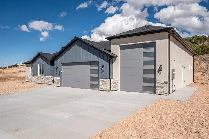 Contemporary exterior with a multi-car garage, stone veneer accents, and modern garage doors with frosted glass panels