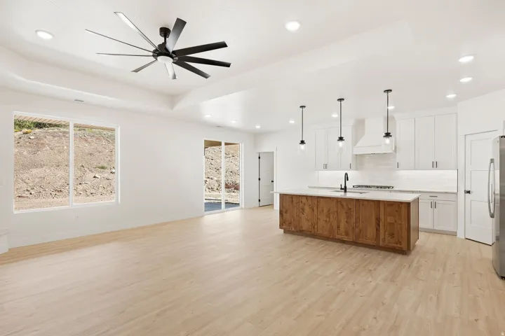 Open-concept living space featuring wood-finish flooring, a contemporary ceiling fan, and recessed lighting