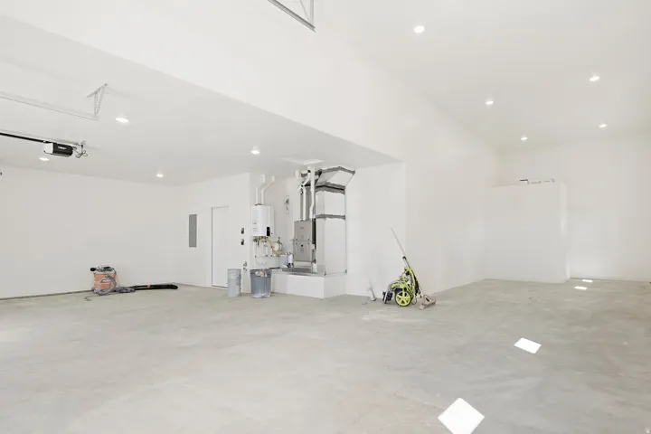 Spacious garage with concrete flooring, recessed lighting, and a white overhead garage door opener