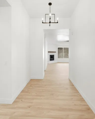 Wood-finish flooring throughout, complemented by a contemporary chandelier