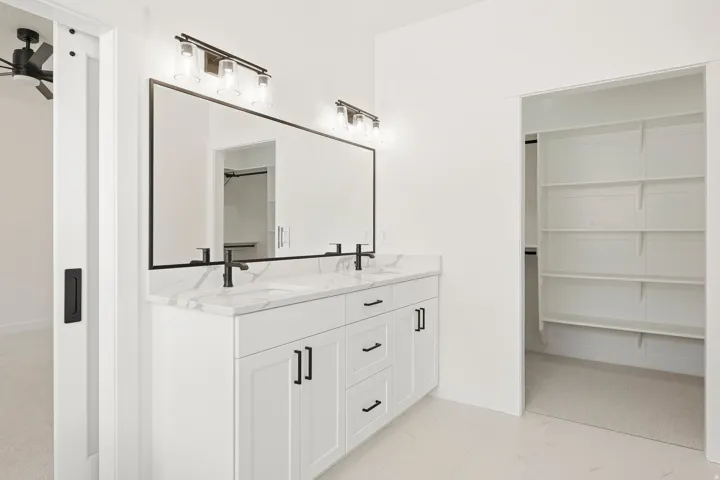 Double vanity with a white countertop, dual sinks, and matte black faucets