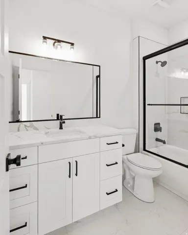 White vanity with a stone countertop and integrated sink