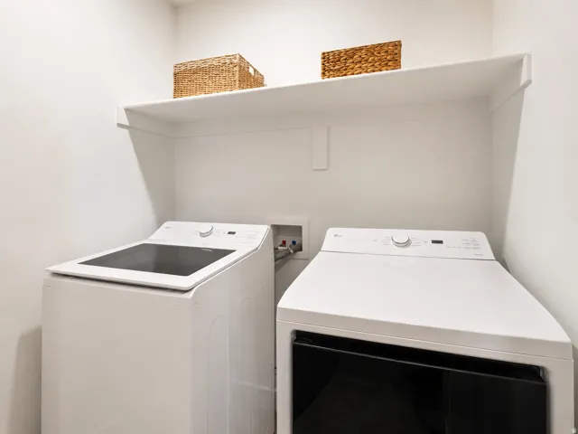 Dedicated laundry area featuring a white top-load washing machine and a white front-load dryer