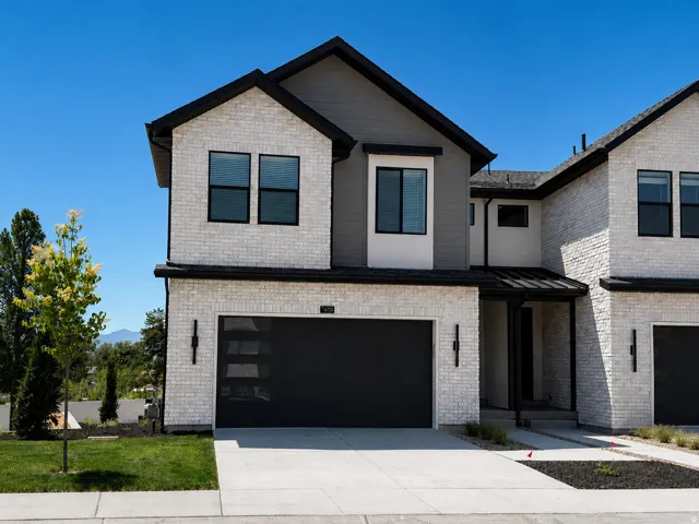 Modern facade featuring white brick, dark gray siding, and black trim
