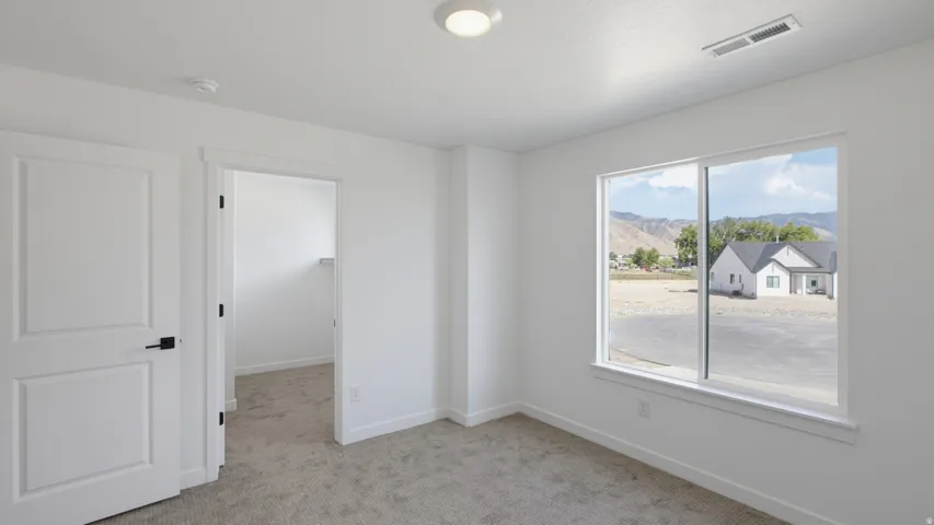 Bright room with neutral wall color, white trim, and carpet flooring