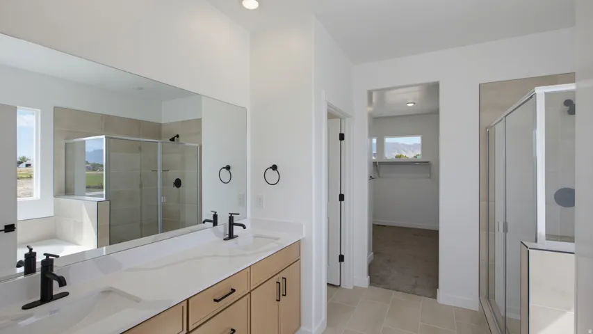 Dual vanity with undermount sinks, white countertop, and matte black fixtures
