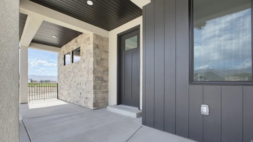 Covered front porch featuring concrete flooring, a dark plank ceiling, and recessed lighting