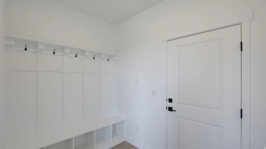 Built-in board and batten bench with cubby storage, integrated shelving, and black hooks