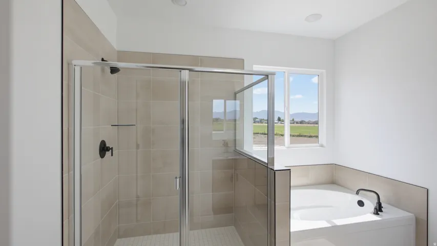 Tiled shower with glass enclosure, recessed lighting, and a built-in bathtub with black fixtures