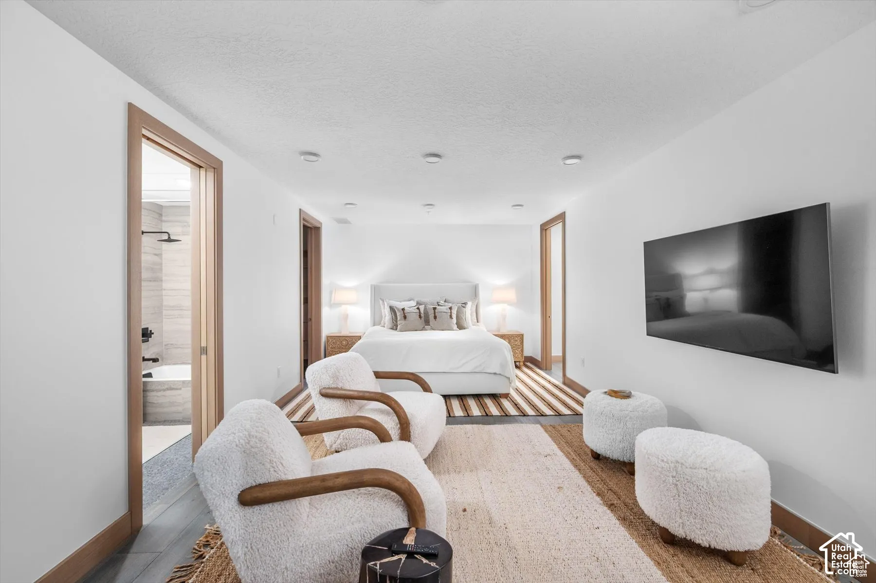 Spacious room featuring wood-finish flooring, recessed lighting, and light wood trim