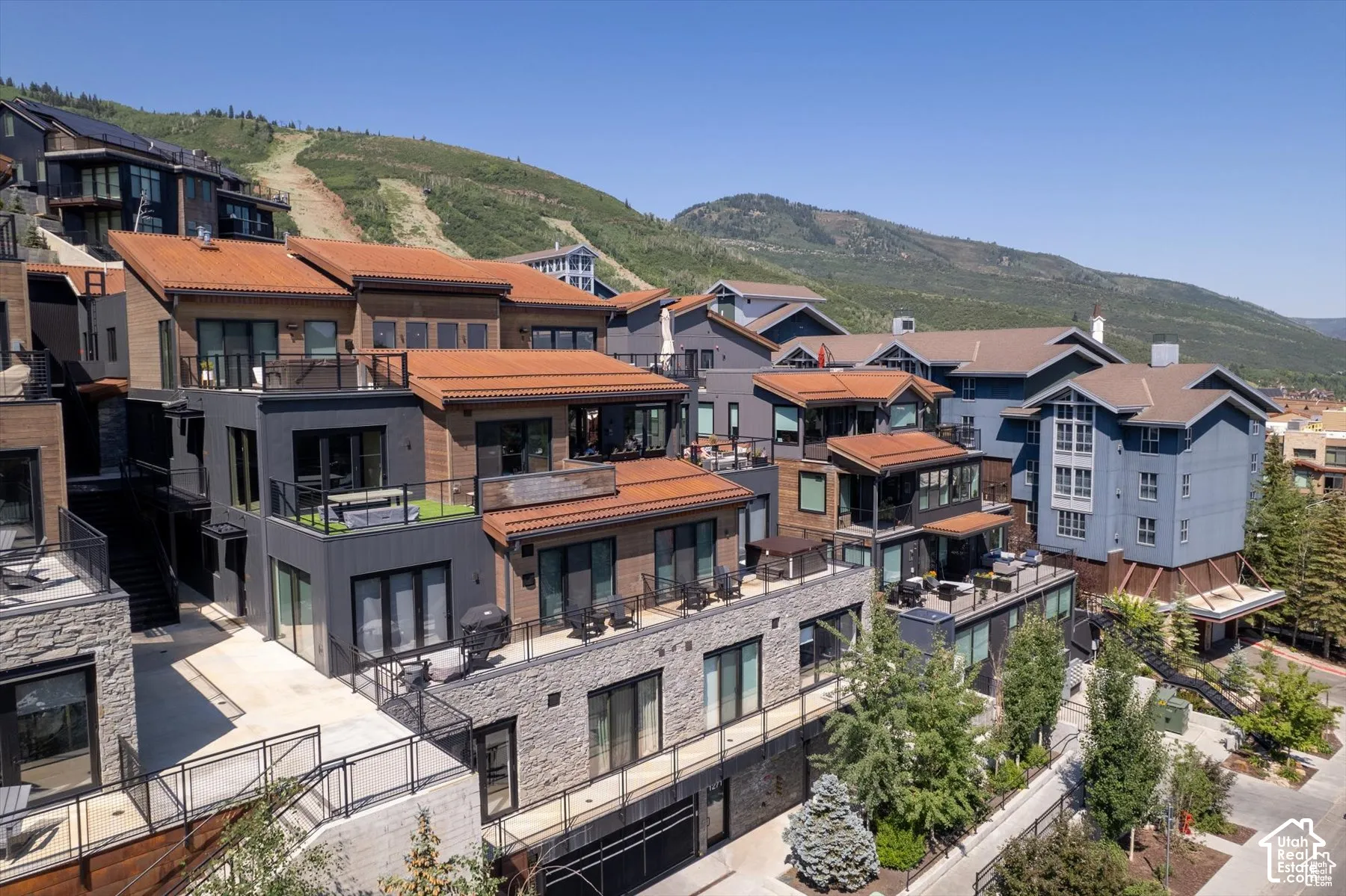 Terraced residences featuring wood siding, dark trim, and red tile roofs
