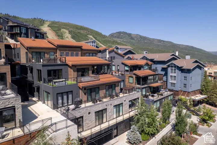Terraced residences featuring wood siding, dark trim, and red tile roofs