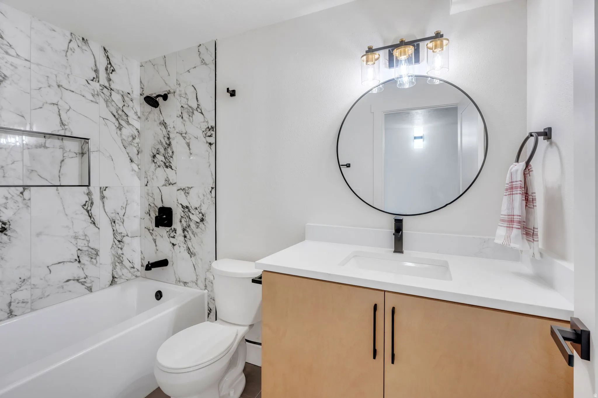 Bathroom featuring a light wood-finish vanity with a white countertop and integrated sink