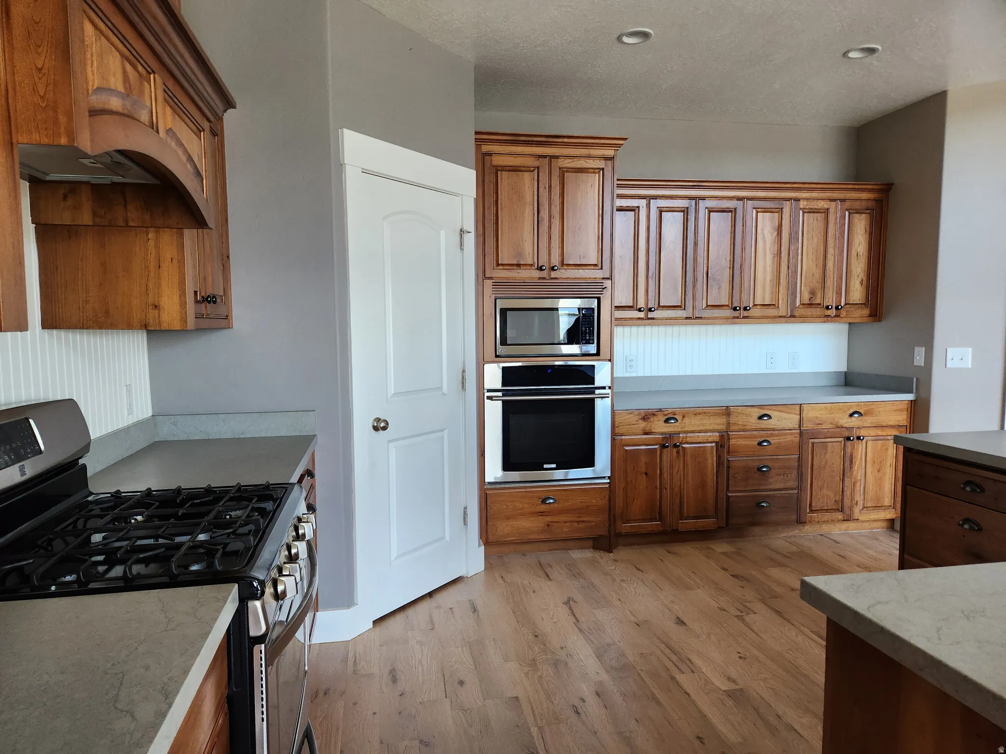 Well-appointed kitchen featuring wood-finish cabinetry, stainless steel appliances, and a gas range