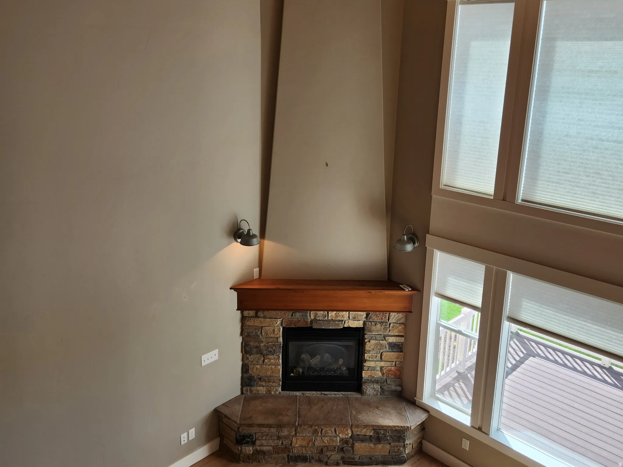 Floor to ceiling custom gas fireplace featuring a stone surround and wood mantel