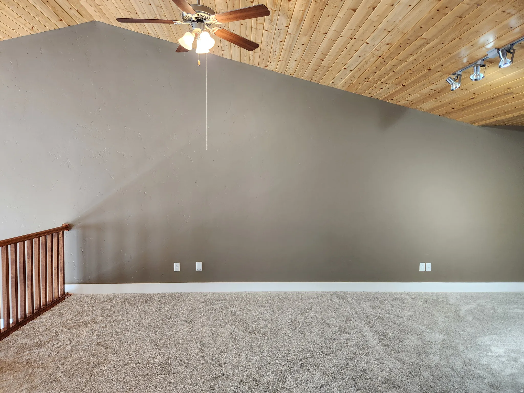 Vaulted wood-paneled ceiling with track lighting and a ceiling fan. Overlooks main floor great room and fireplace.  Amazing views from 2-story windows.
