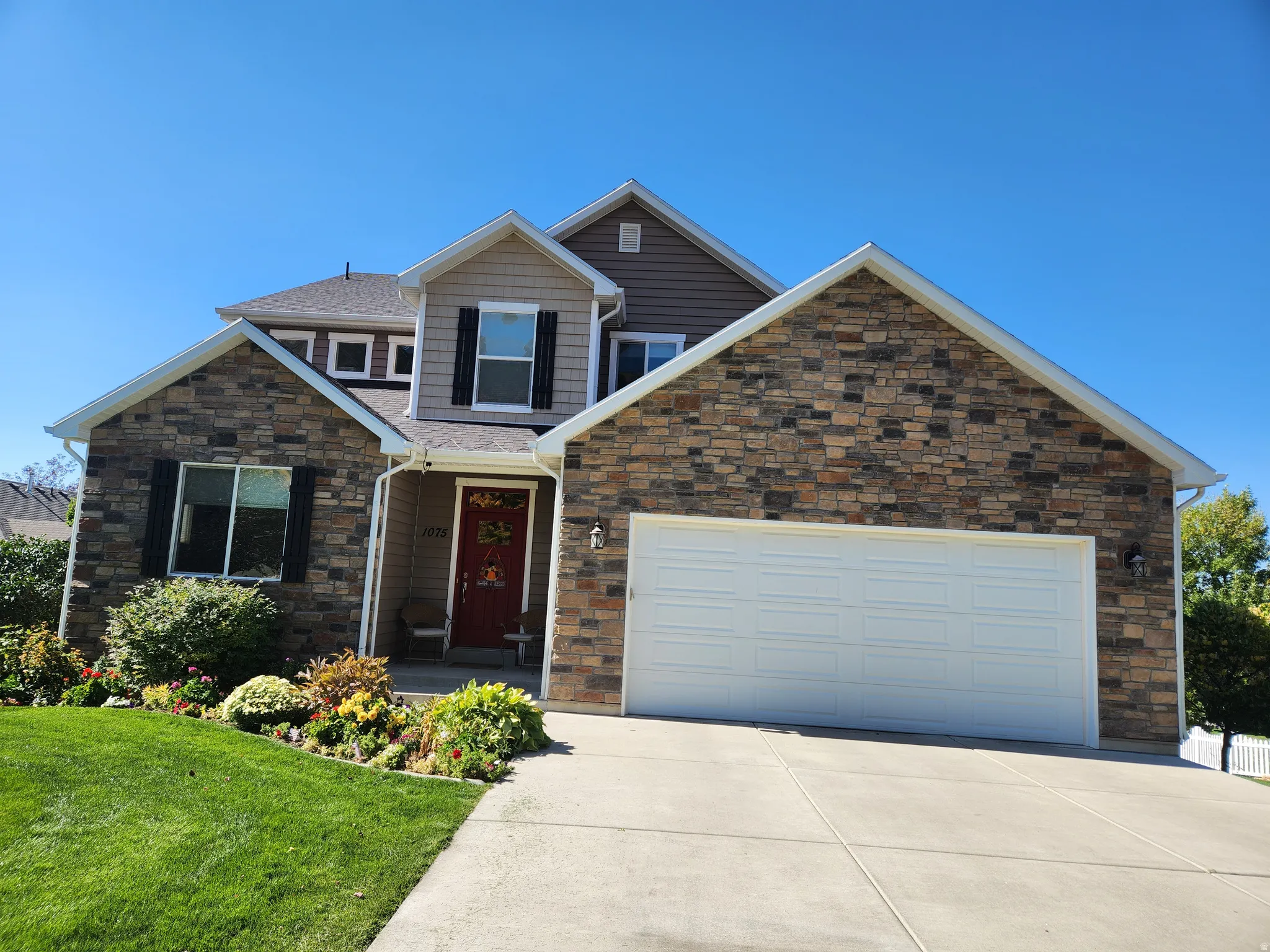 Stone and siding exterior with an over-sized two-car garage. Huge barn for more cars in the rear.
