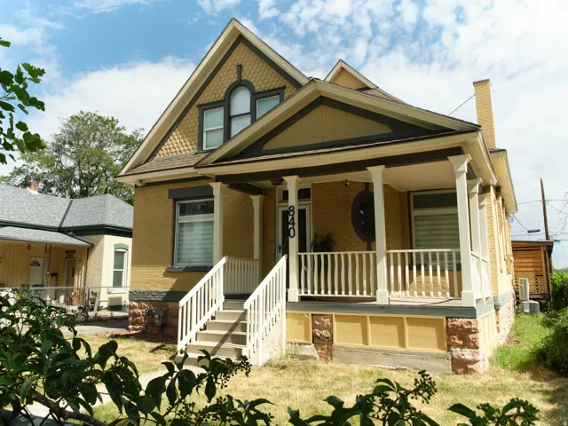 Victorian-style residence featuring a prominent front porch with white railings and columns