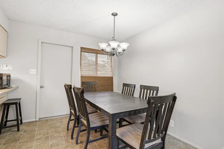 Dining area with tiled flooring, neutral wall paint, and a multi-light chandelier