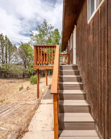 Exterior wood siding complements a multi-level deck and staircase featuring wood railings