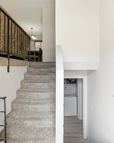 Carpeted staircase with an ornamental metal railing