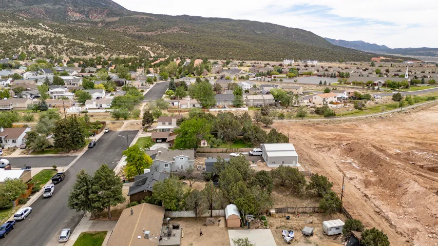 Residential neighborhood with a variety of single-family homes, mature trees, and mountainous terrain