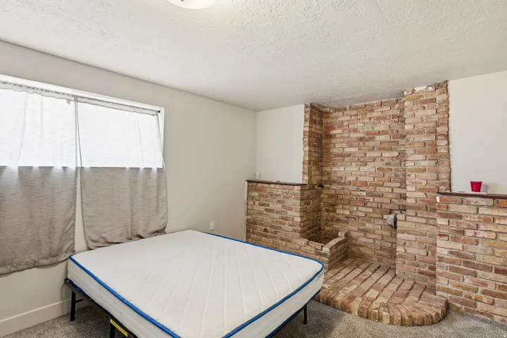 Interior space featuring a brick-faced accent wall with a built-in hearth