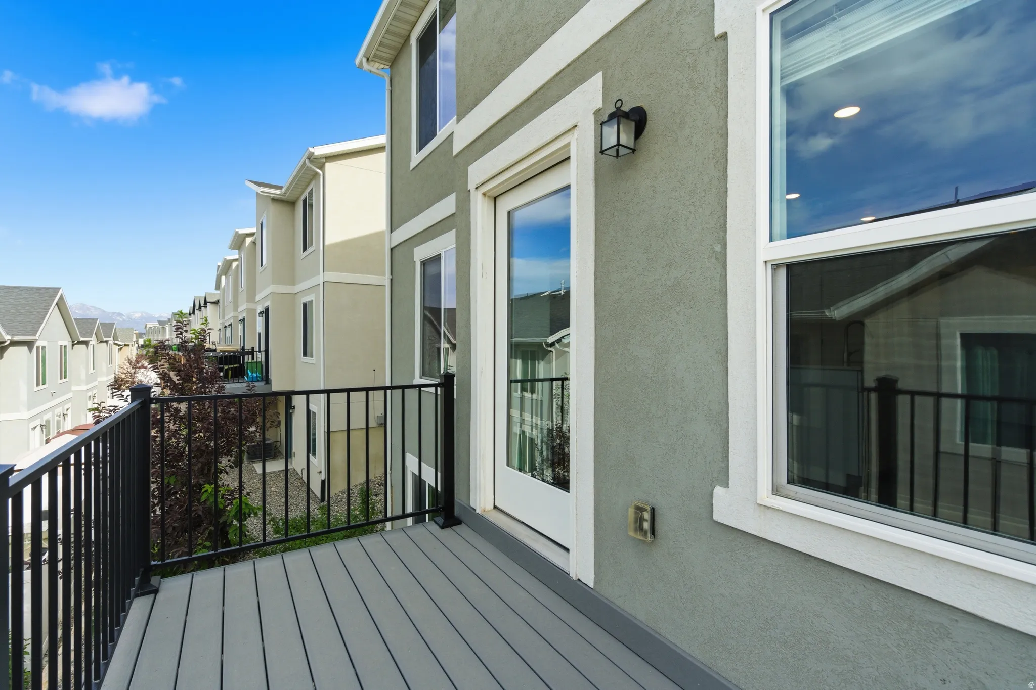 Private balcony featuring composite decking and black metal railing