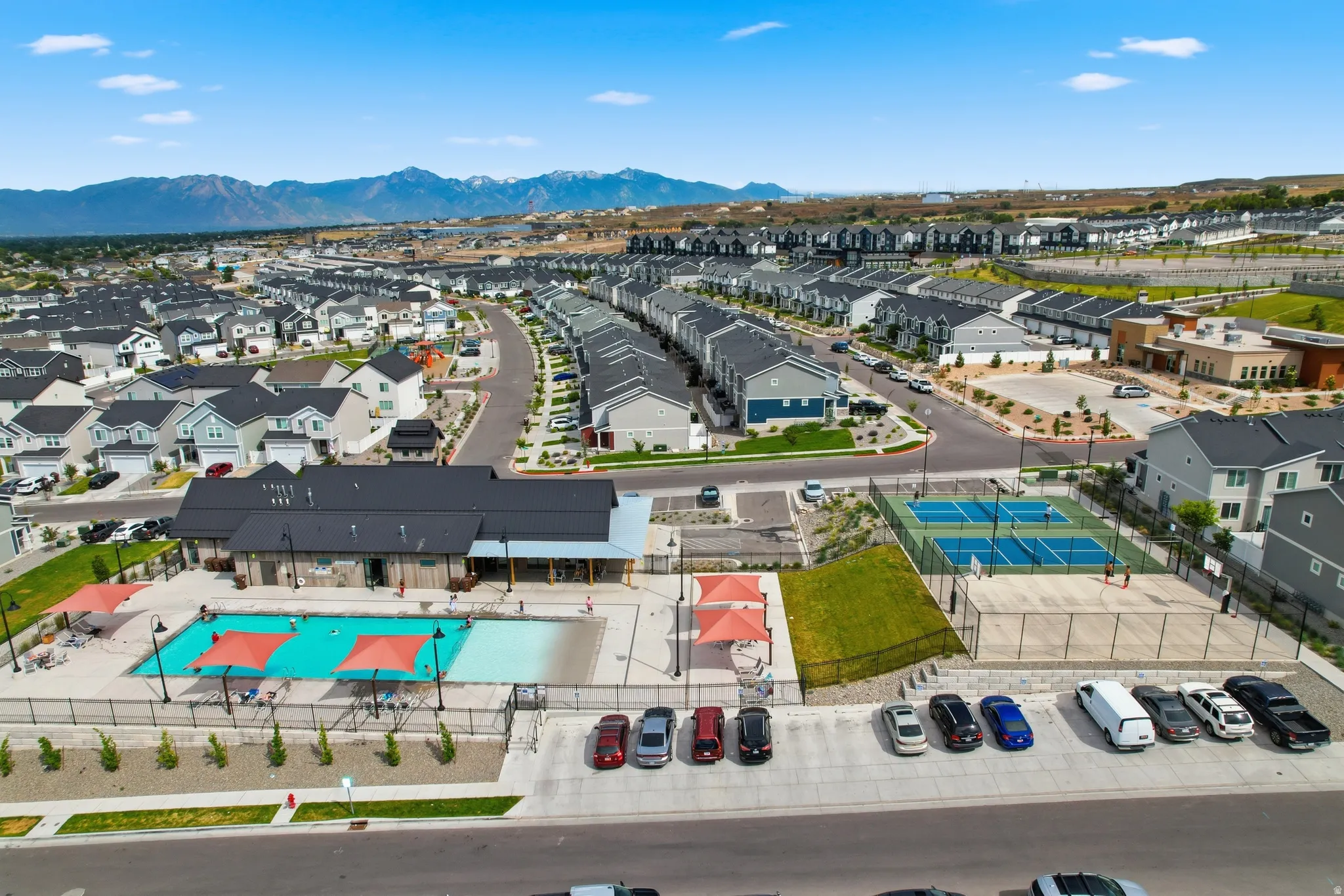 Community amenities featuring a swimming pool, clubhouse, multiple sports courts, and mountain backdrop
